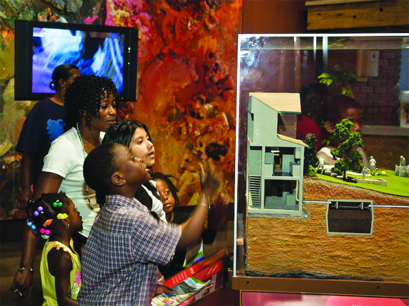 kids and adult looking at glass display of city
